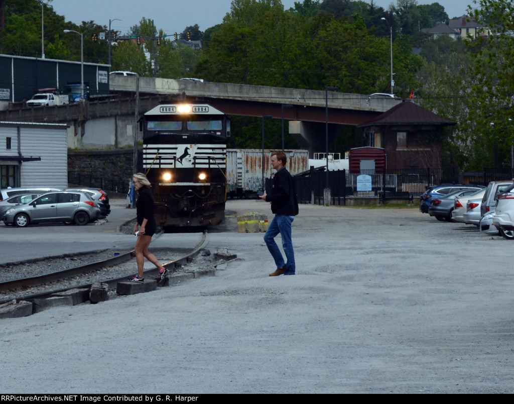 Pedestrians cross the NS "Old Main Line" in front of a stopped E19 yard job.